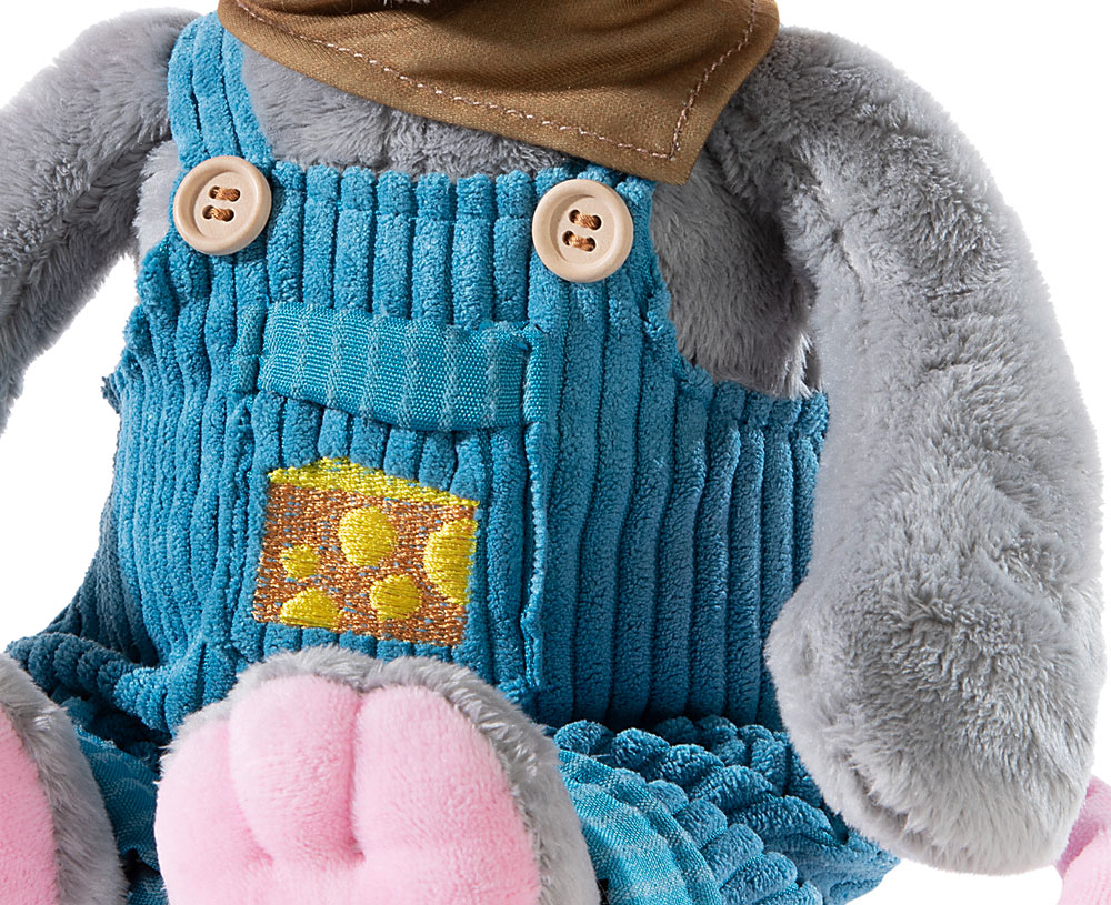 Weiches Plüschtier mit blauer Latzhose und Halstuch Nahaufnahme eines Plüschtiers in blauer Latzhose mit gelbem Motiv und braunem Halstuch